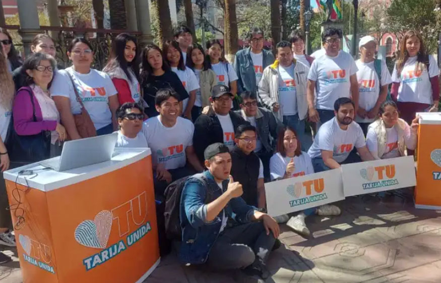 El equipo de la agrupación Tarija Unida, compuesto mayormente por jóvenes, posa sonriente para una foto grupal durante su presentación oficial en una plaza de la ciudad.